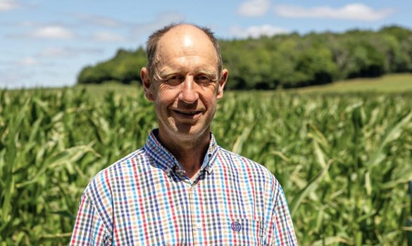 Headshot of a man (Jamie Butler) wearing a checked shirt stood in a field growing a tall crop.
